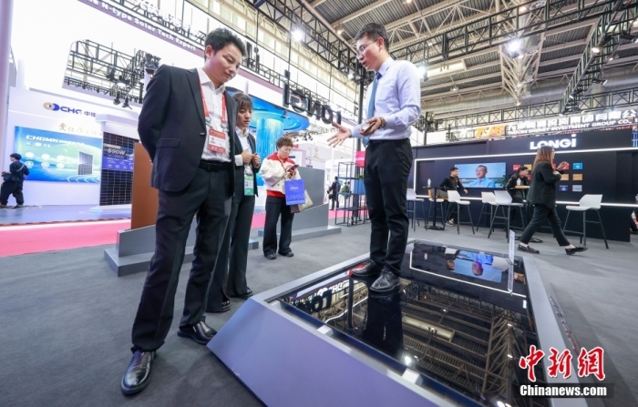 11月28日，首届中国国际供应链促进博览会在北京开幕。图为某光伏企业展商向观众展示一款可以踩踏的光伏板。<a target='_blank' href='/'>中新社</a>记者 贾天勇 摄
