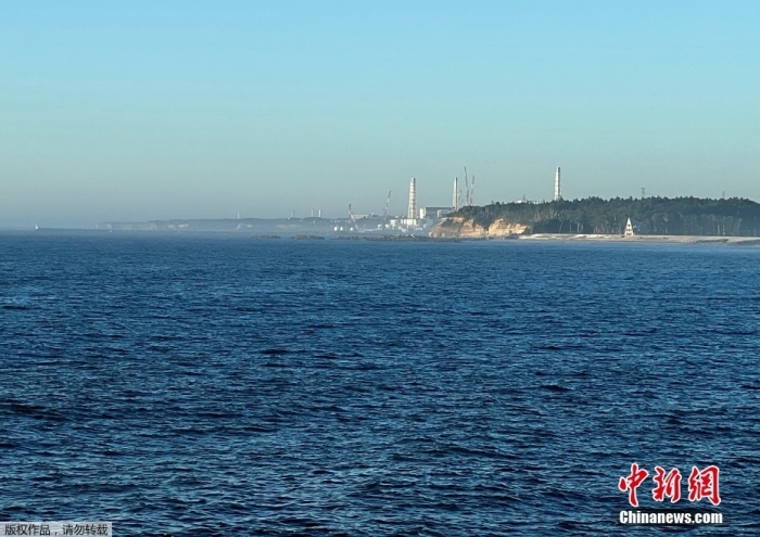 资料图：当地时间2023年8月25日，从日本福岛Namie镇附近的渔港远眺福岛第一核电站排放核污染水。