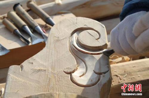 图为手工雕刻的房屋木花。李隽 摄
