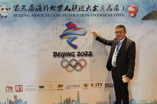 第三届海外北京人联谊大会主席、澳大利亚北京会会长高鹏在助力冬奥签名板上签名。