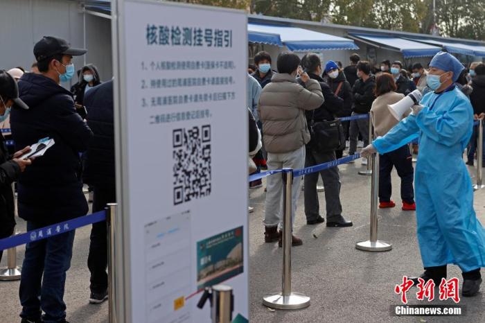 保安人员提醒排队民众保持一米间距。 殷立勤 摄 点击进入下一页