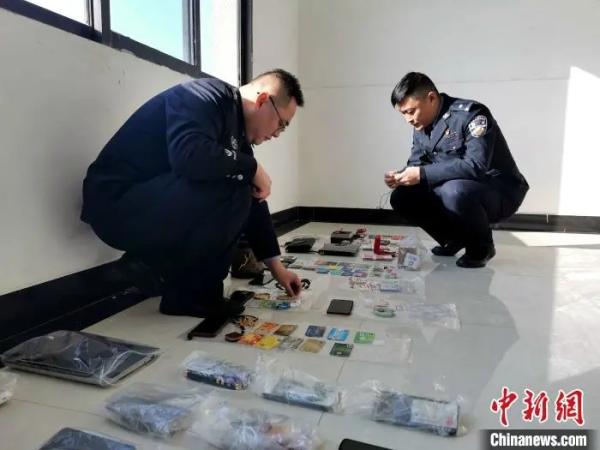 资料图：湖北警方打掉一藏匿境外电诈团伙，抓获嫌犯42人。图为办案民警清点涉案财物　胡传林　摄