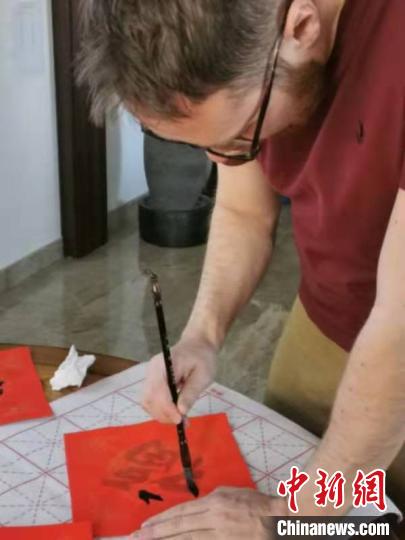 图为艾伦在写福字。受访者供图 图为艾伦在写福字。受访者供图